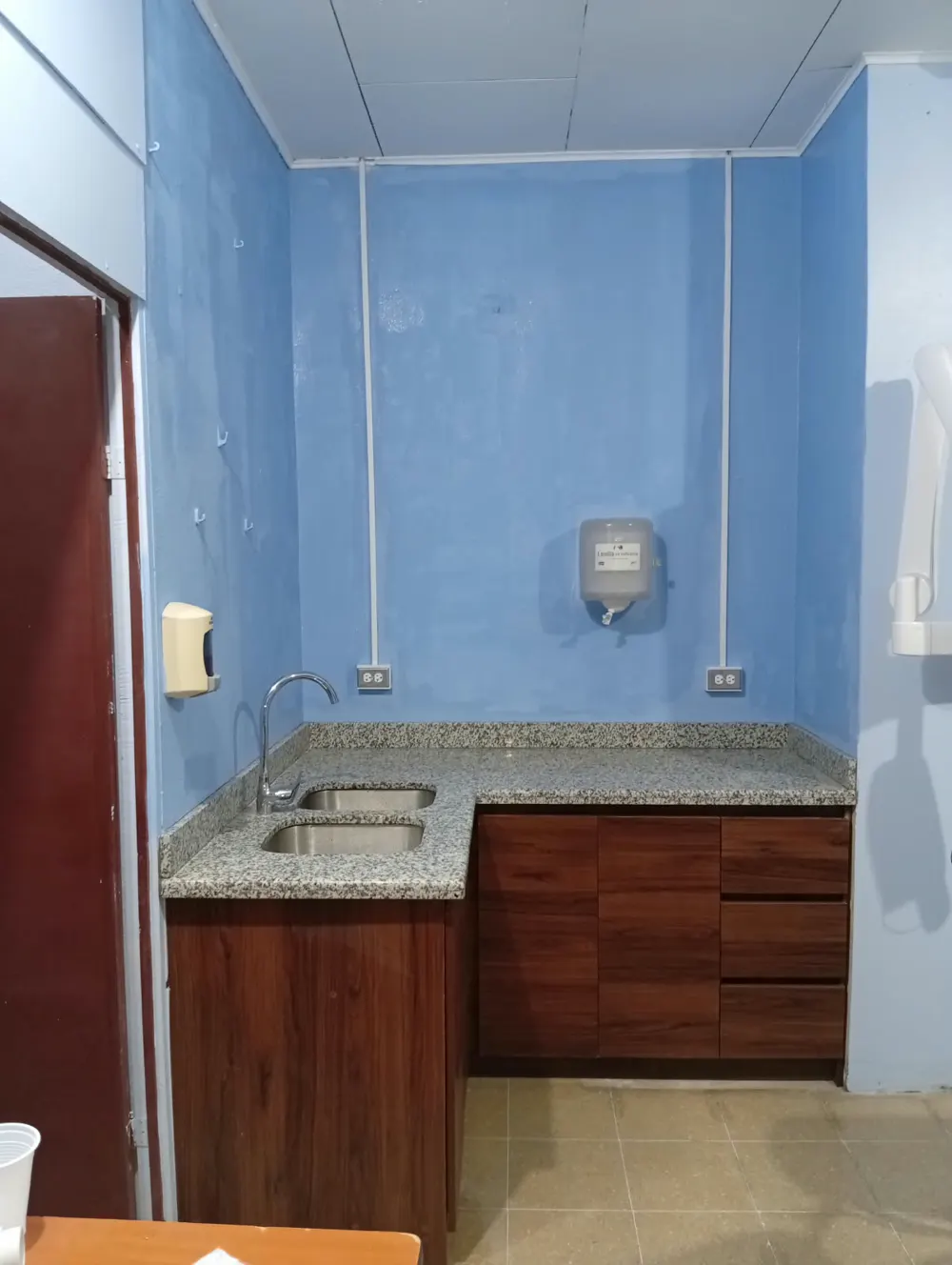 Dos tomacorrientes sobre un mueble de cocina, alimentados por canaleta vertical